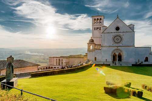 Panorama of Assisi, home of St. Francis, in the umbria region of Italy famous for the pilgrimage cathedral of the popes of all ages / DD25 - stock.adobe.com Church, Umbria, Italy, Assisi, religion, holy, sunset, building, catholic, landscape, monument, belief, people, family, children, prayer, miracles, holidays, countryside, brick, marble, Pope, Vatican bell, mercy, excellence, death, resurrect, world,